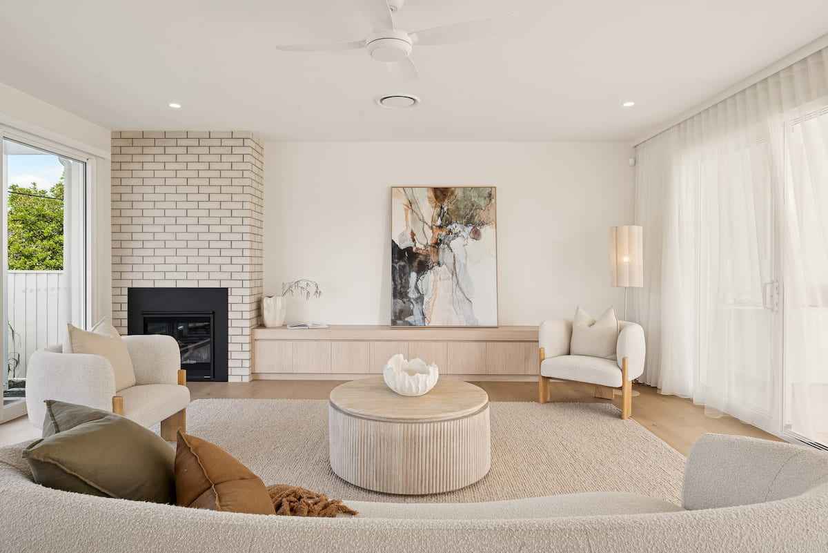 Living room with brick fireplace, boucle sofa and abstract artwork